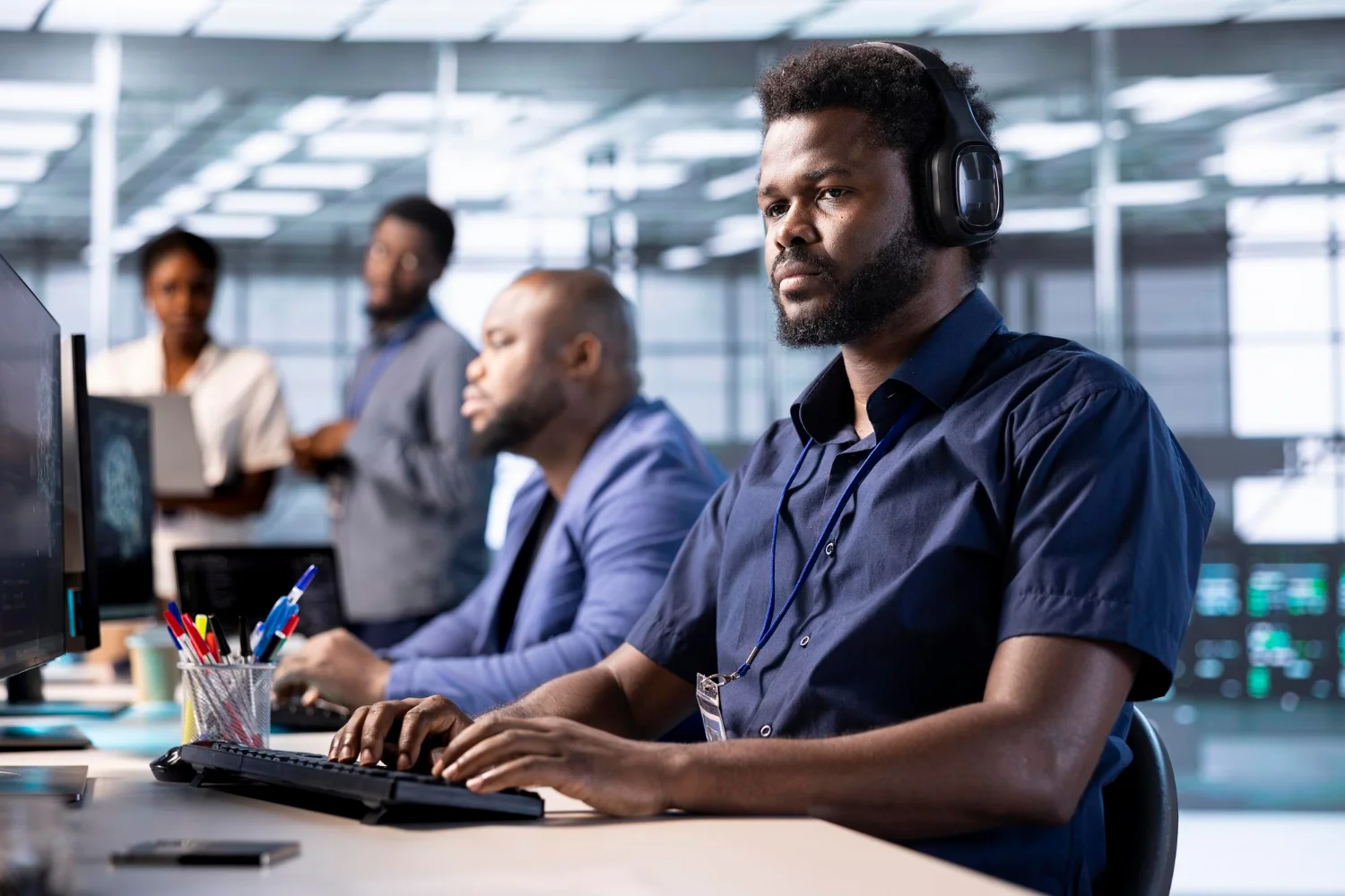 An agent focused on a call while the team works behind him