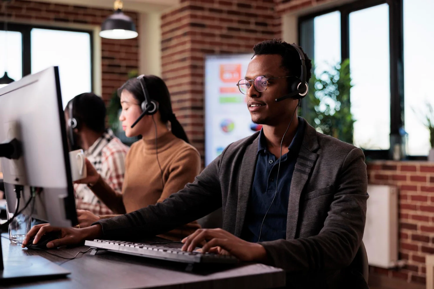 A multilingual team working side by side on headsets